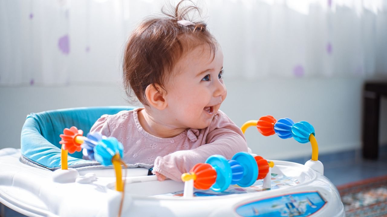 The Art of Drawing Readers In: Your attractive post title goes here A joyful baby enjoying playtime in a vibrant walker indoors.