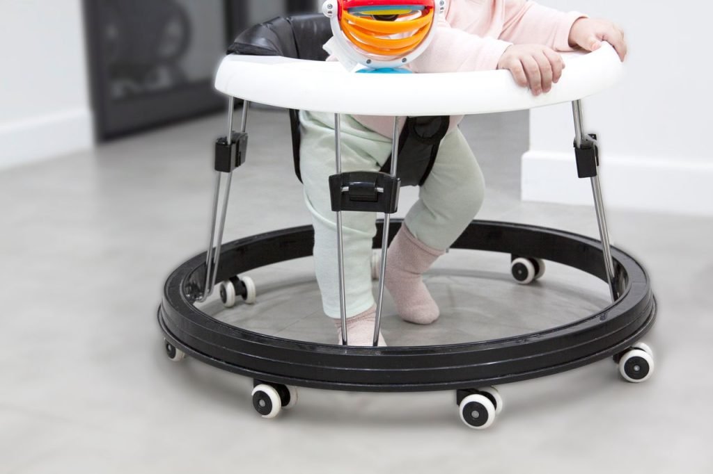 Mastering the First Impression: Your intriguing post title goes here Adorable baby learning to walk using a colorful baby walker indoors.