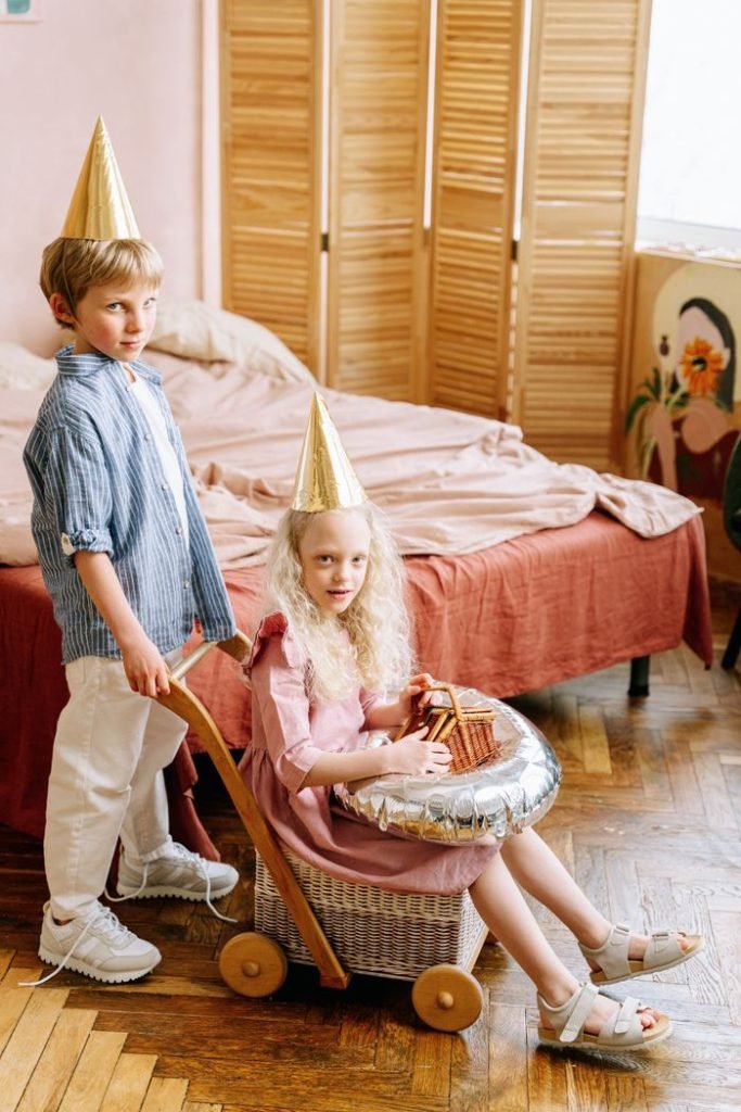 Kids dressed up for a birthday party with hats, enjoying in a cozy bedroom setting.